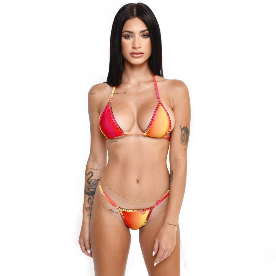 Brunette Female Model Showcasing a Luxury Crochet-Trimmed Bikini in Red and Yellow Gradient while posing in front of a pure white background.