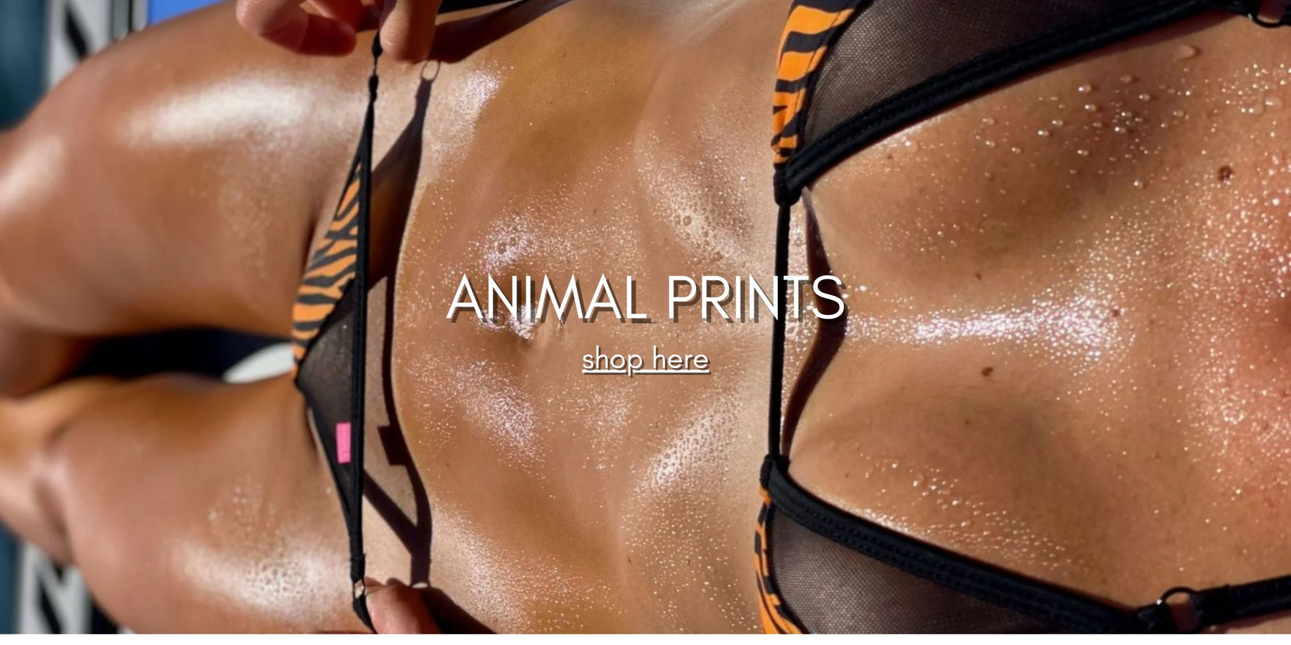 Tanned Female Model sunbathing to showcase a partially sheer micro bikini with a Tiger Stripes Animal Print.