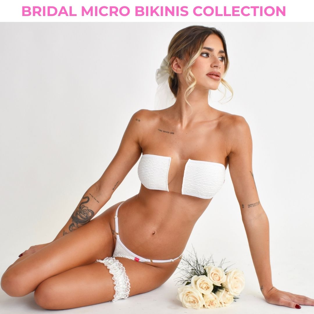 Model showcasing a white bridal bandeau bikini while posing with a white roses bouquet